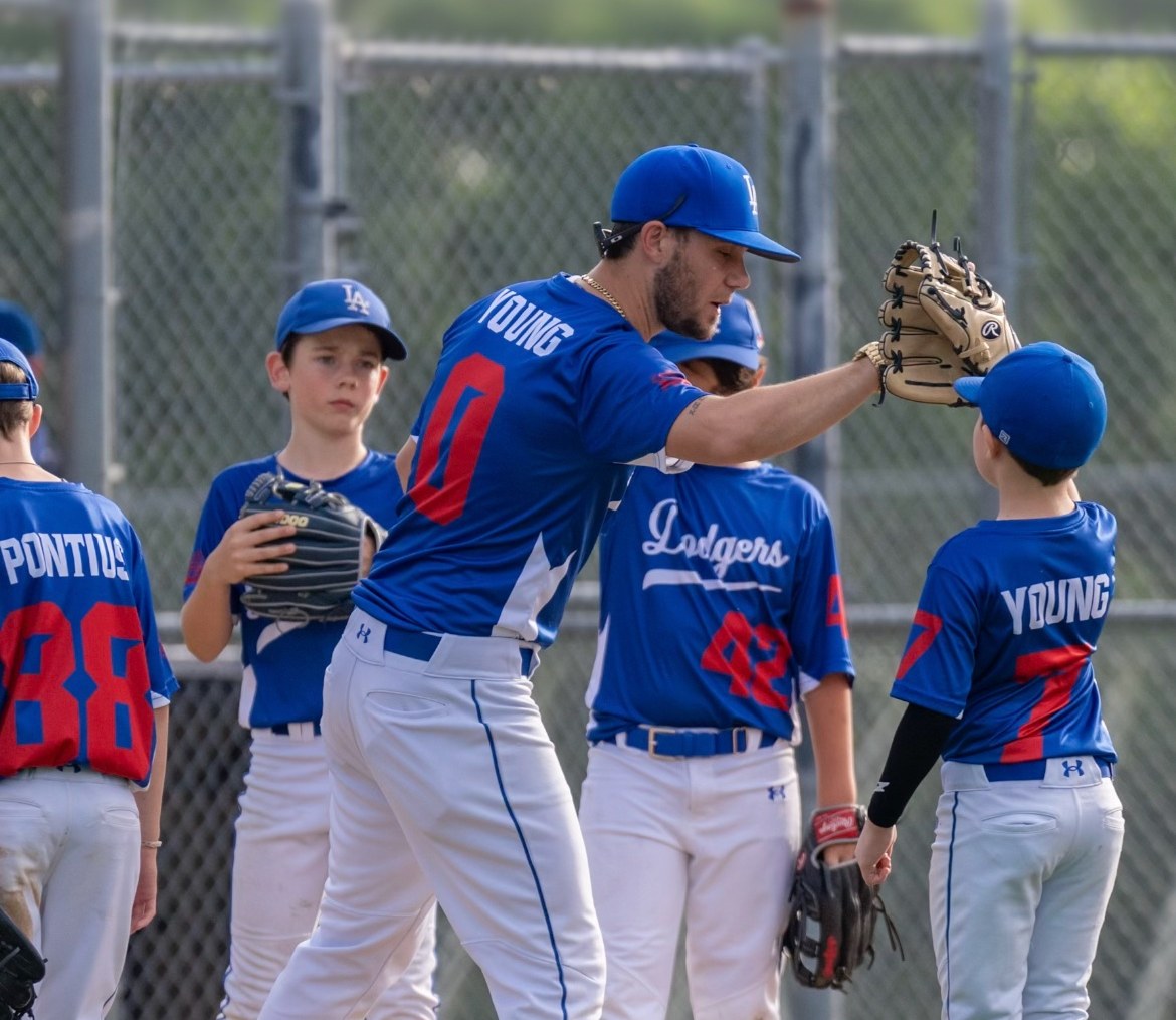 Matt Young giving a glove high-five to a young Dodgers player on the field