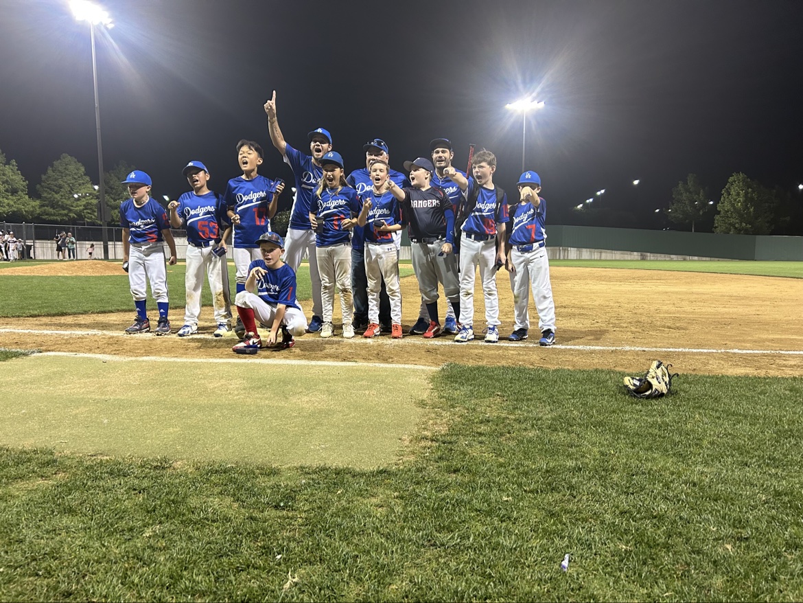 Matt Young's Dodgers team celebrating together on the field under the lights