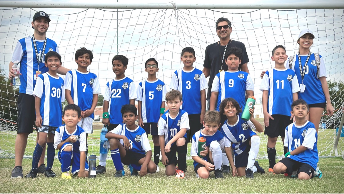 Matt Young with a youth soccer team posing in front of the goal