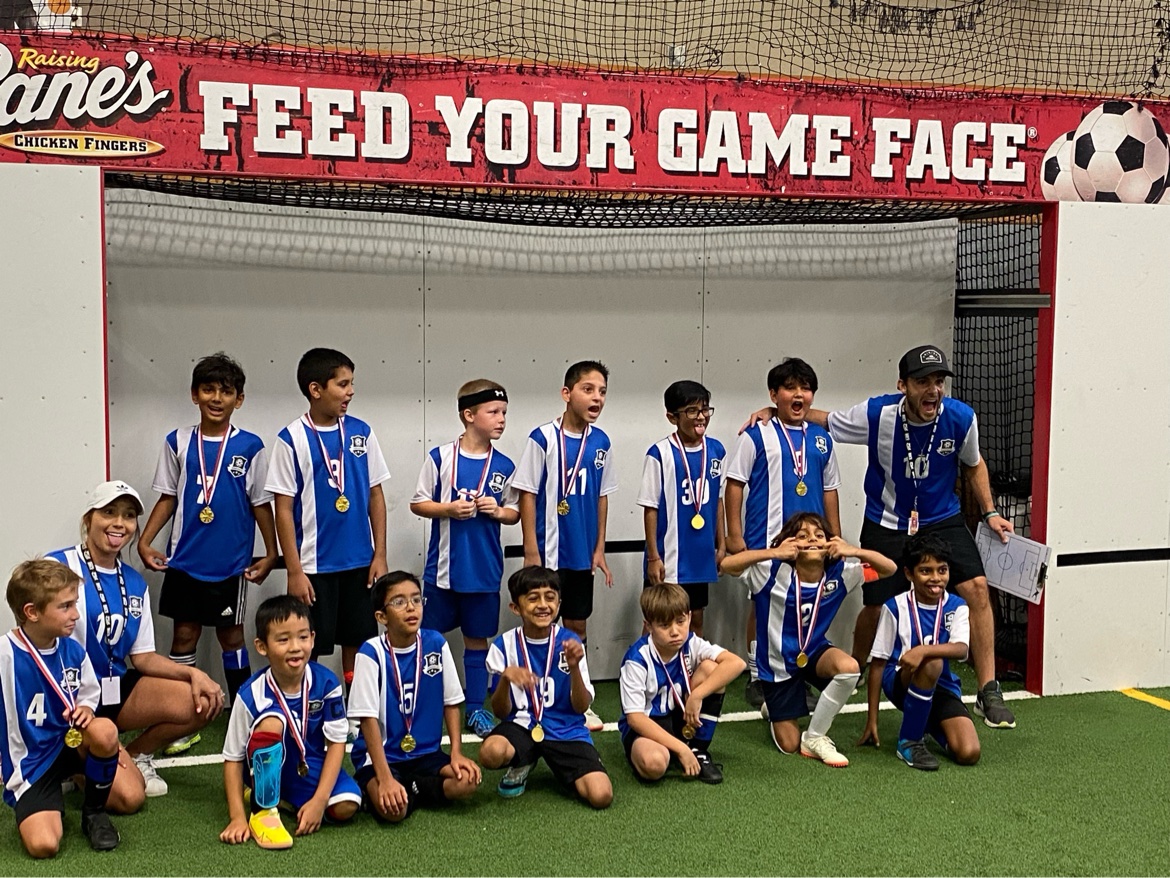 Matt Young celebrating with a youth soccer team wearing their medals